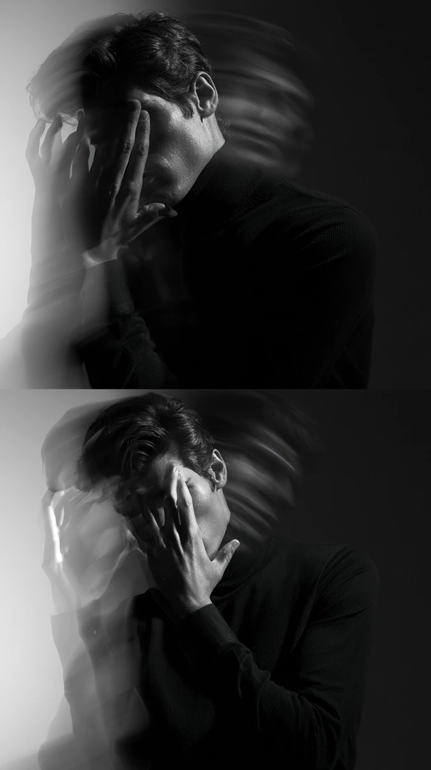 Two stacked monochrome portraits of a man in a black turtleneck shielding his face with his hands, head whipping in motion blur to streak hair into ghosted arcs. Hard studio key light against a soft gradient backdrop. Graphic editorial minimalism, kinetic black-and-white flyer aesthetic.