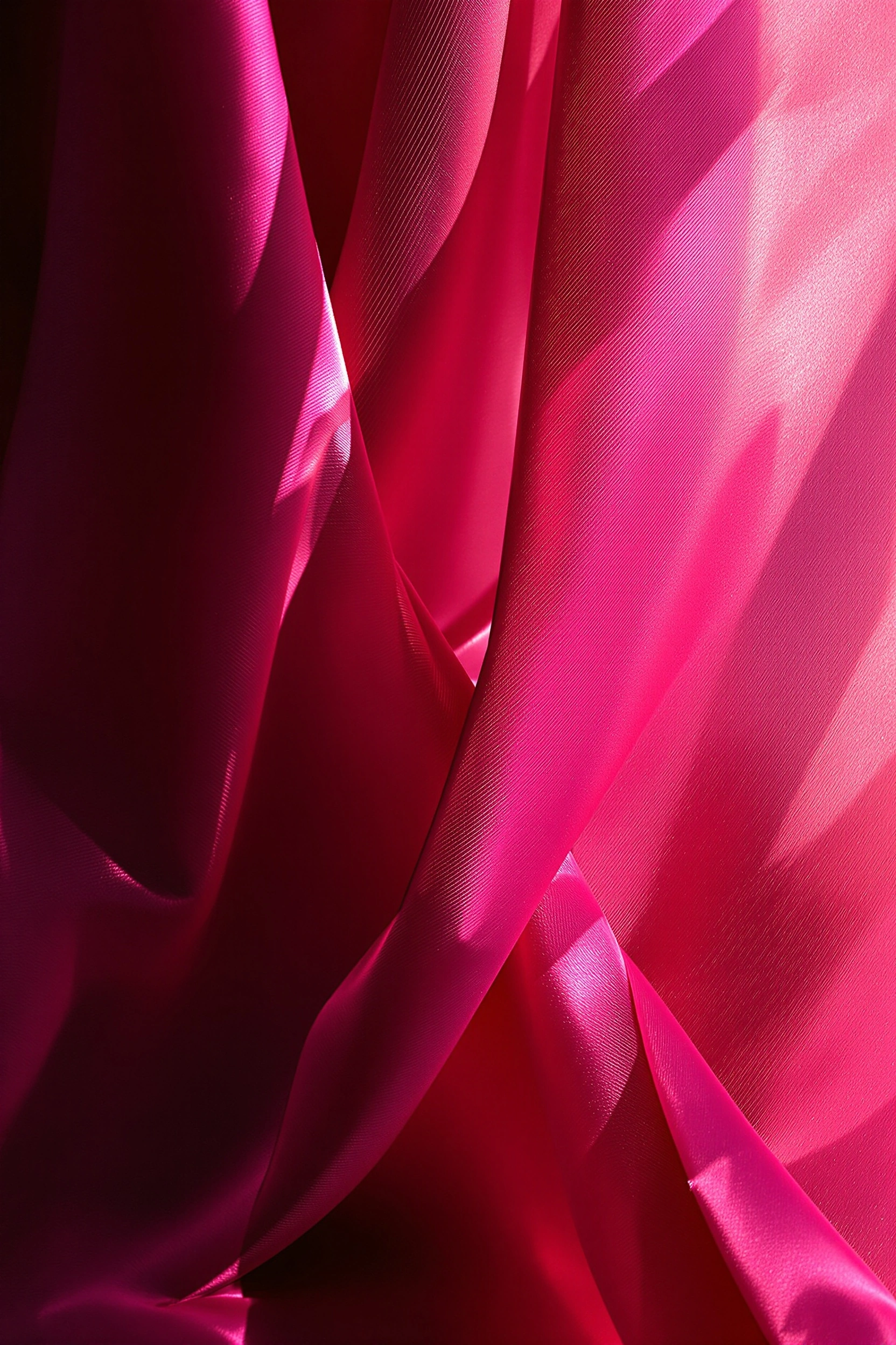 Heavy fuchsia silk cascades in deep vertical folds, low side light skimming the weave so each ridge ignites in hot magenta while the troughs sink toward burgundy. Subtle diagonal grain of the satin is visible across the brightest planes. Pure abstraction in saturated rose, studio macro precision with creamy 5400K daylight color rendition.