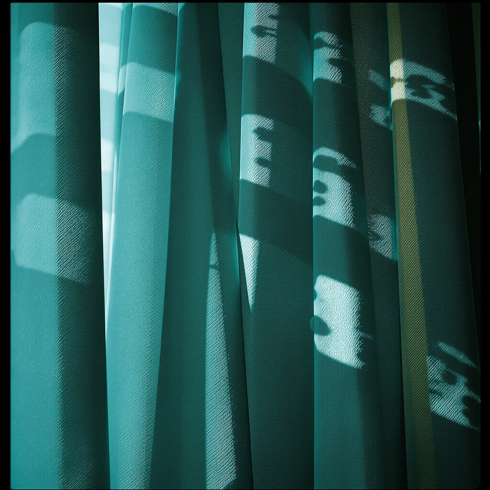Heavy teal silk hanging in vertical pleats, sliced by sharp rectangular patches of daylight that telegraph a mullioned window beyond. The weave catches the cool 5400K light, deepening shadows into near-blackened jade in the recessed folds. Square frame, painterly chiaroscuro, quiet cinematic tension.
